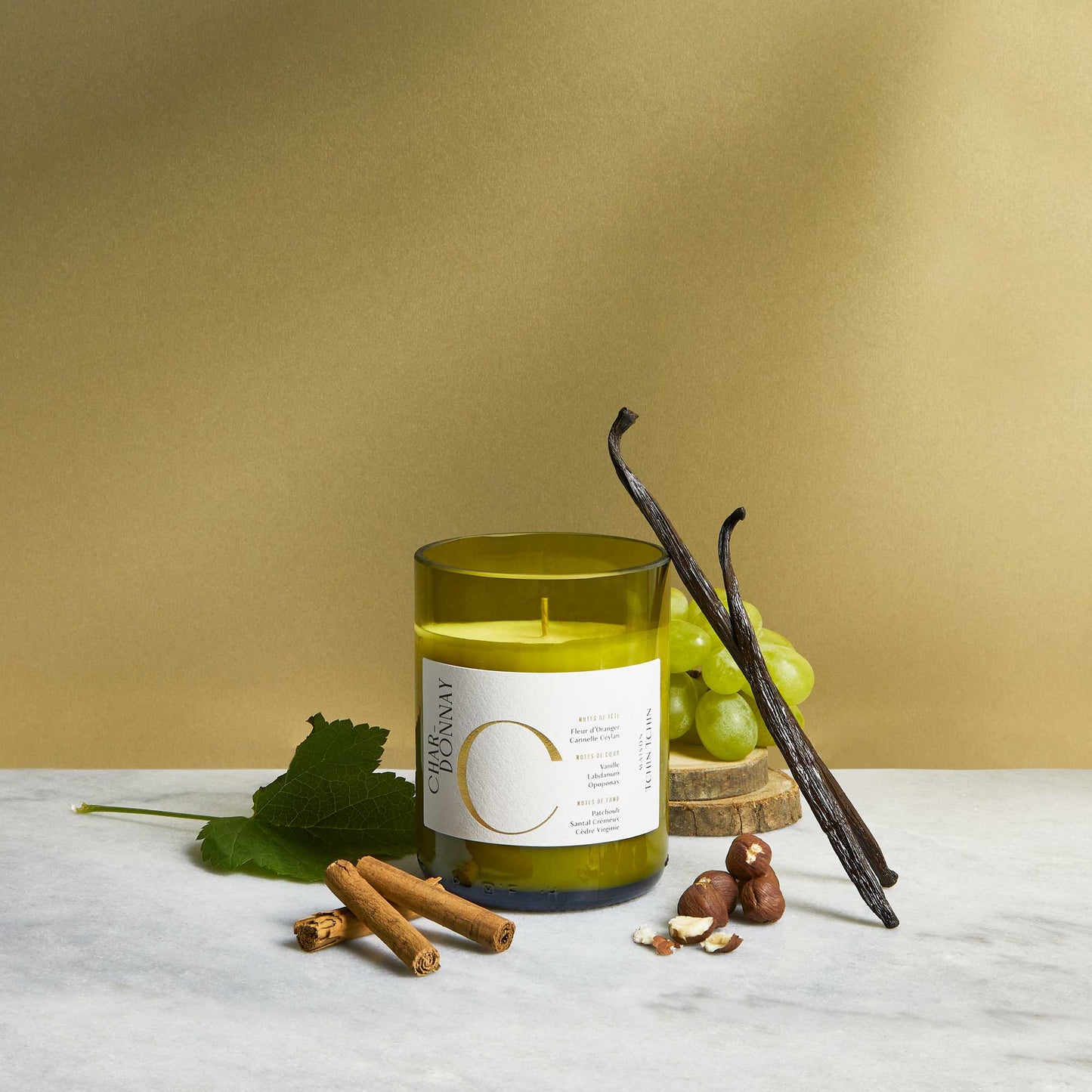 Maison Tchin Tchin bougie parfumée artisanale senteur Chardonnay posée avec des gousses de vanille, des bâtons de cannelle