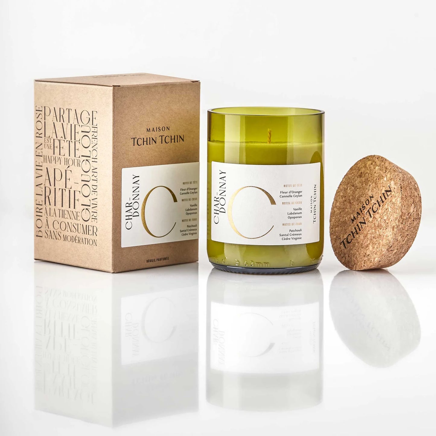 Maison Tchin Tchin bougie parfumée artisanale fabriquée en France à côté de sa boîte, coulée dans une bouteille de vin upcyclée