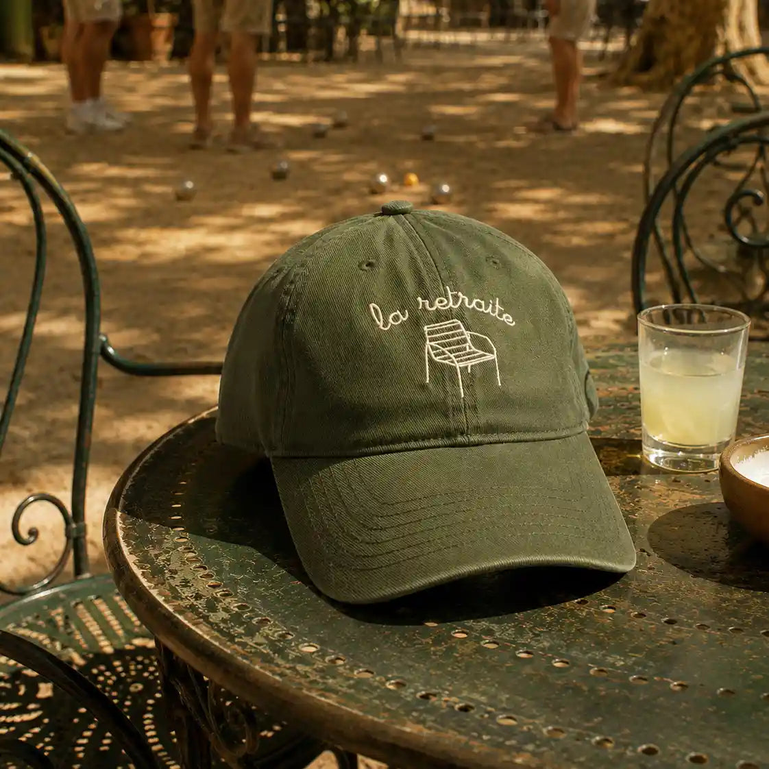 Casquette la retraite à message brodé posée sur une table de restaurant sur la place d'un village dans le sud de la France
