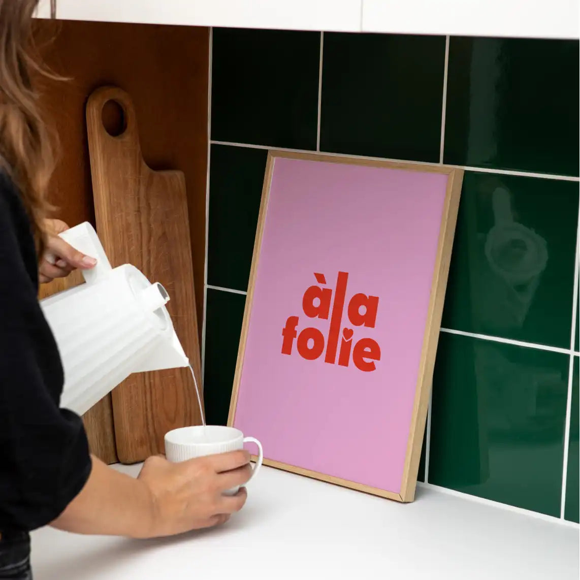 Affiche Papier and Co "à la folie" rose encadrée et posée sur le comptoir d'une cuisine