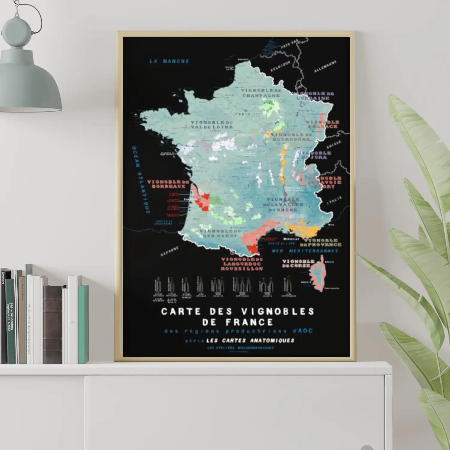 Carte des vignobles de France au format 50x70cm par les Ateliers Mulkographiques encadrée et posée sur une étagère