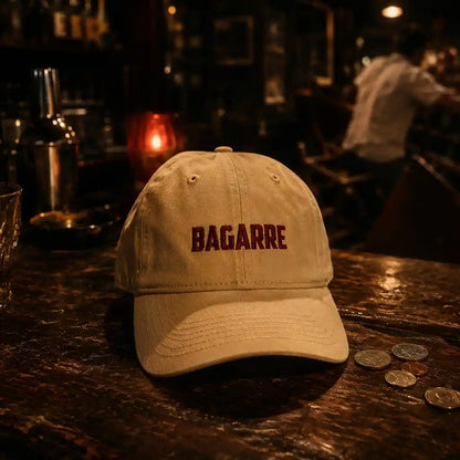Casquette à message brodée Bagarre beige et rouge posée sur un comptoir de bar