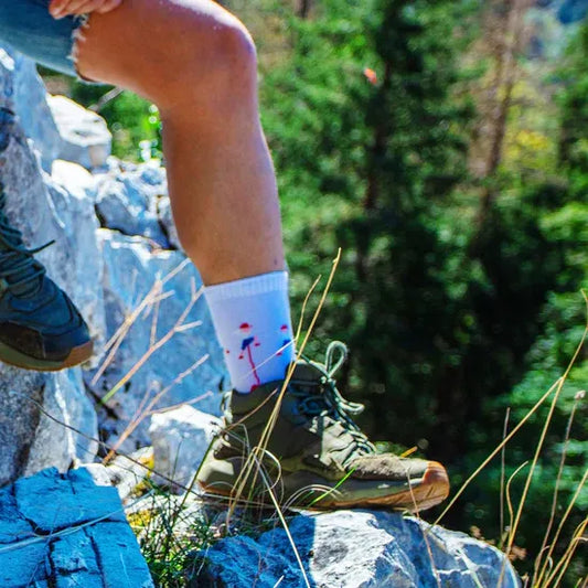 Randonneur portant une paire de chaussettes bleue en coton, originales, modèle Les Grimpeurs de la marque Pierre-Lou des Alpes