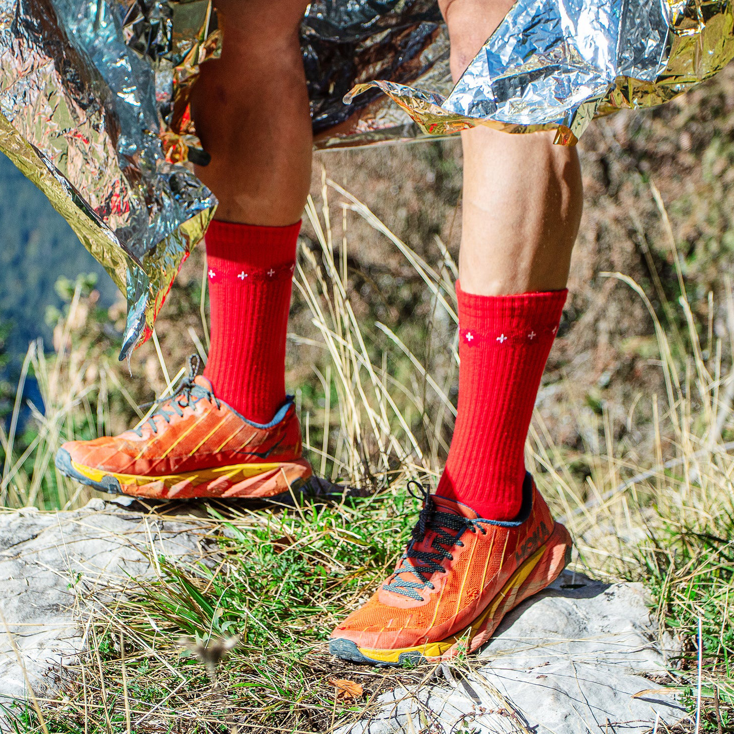 Randonneur portant des chaussettes rouges montantes en coton bio de la marque Pierre Lou des Alpes
