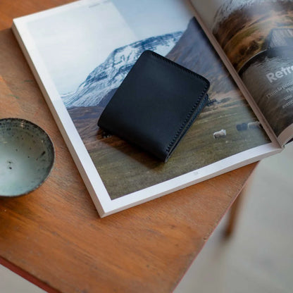 Portefeuille en cuir pour homme Peze de Bleu de Chauffe posé sur une table 