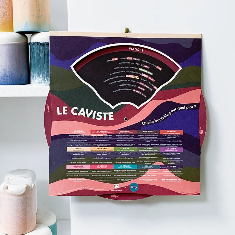 La roue du caviste : le guide pour accorder mets et vins par Papier Tigre accroché au mur d'une cuisine
