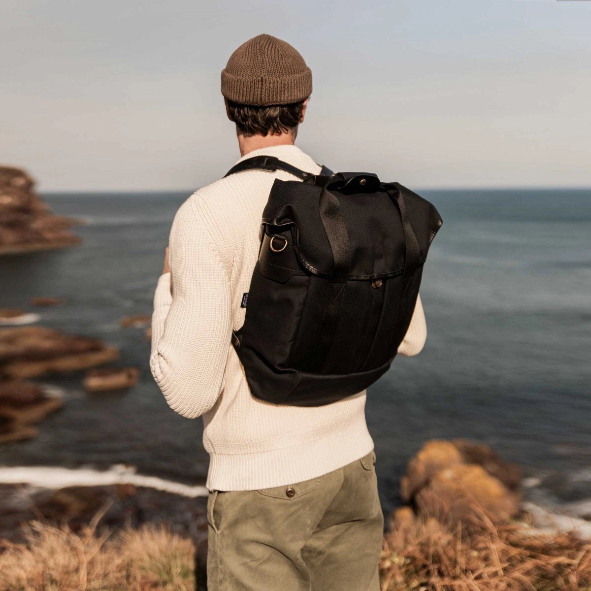 Jeune homme en weekend à la mer portant le sac à dos Chiloé noir de chez Bleu de Chauffe