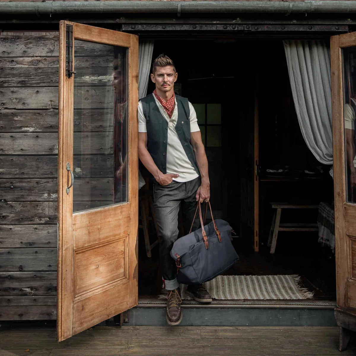 Mannequin portant un sac de voyage cabine en toile bleu marine fabriqué en France par Bleu de Chauffe